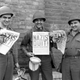 U.S. Ninth Army soldiers smiling while holding copies of ‘The Stars and Stripes’ announcing Germany’s surrender in World War II. 8th May 1945.